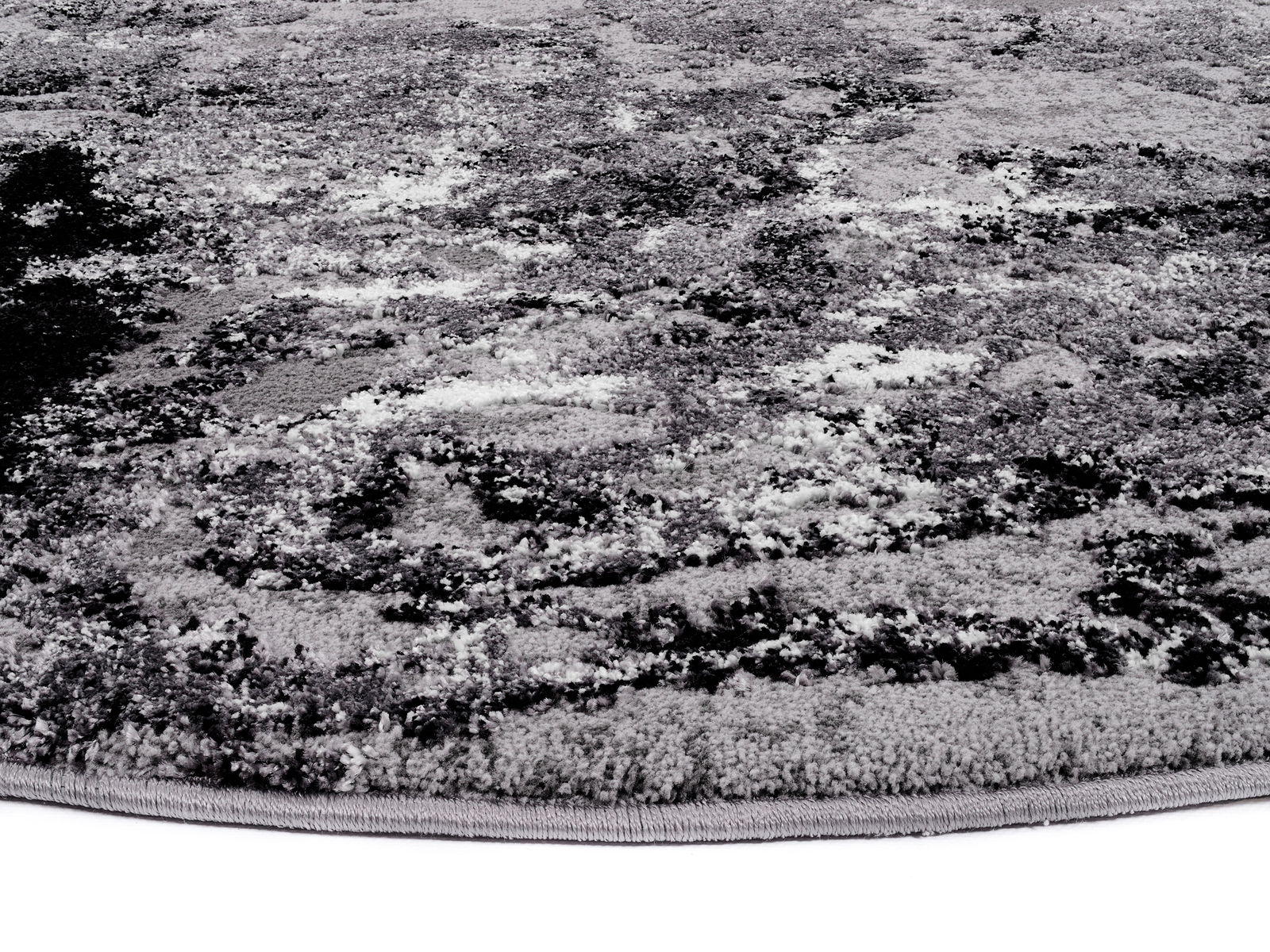 Nahaufnahme eines Designer Teppichs mit abstraktem Muster in Grautönen, seitliche Perspektive