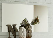 XL-Spiegel an einer Ziegelwand, dekoriert mit Vasen und einem Buchstaben, seitliche Perspektive