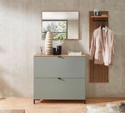 Moderner Garderobenbereich mit einem grünen Hänge-Schuhschrank, einem Spiegel und einer Garderobenleiste mit Jacke, aus der Frontalperspektive fotografiert.