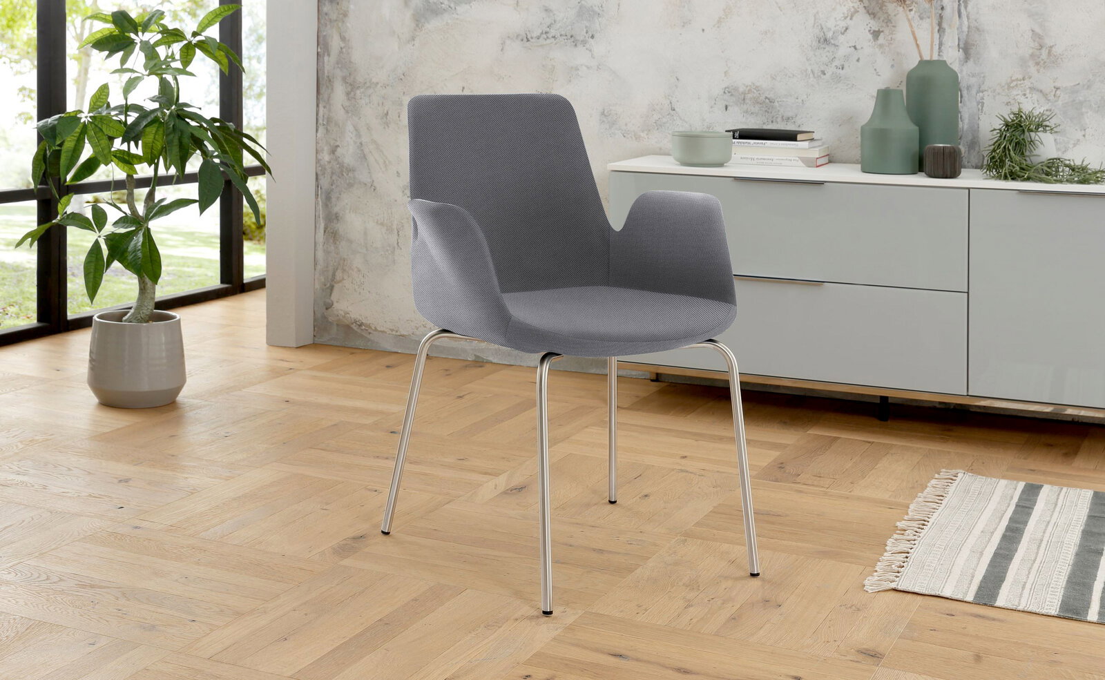 Venda Besuchersessel MY HELIOS Grauer Besuchersessel mit Metallbeinen in einem modernen Raum, seitliche Perspektive