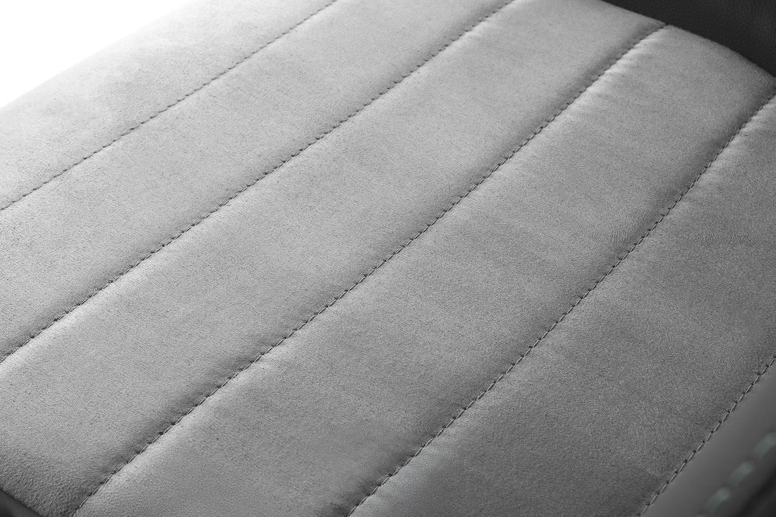 Nahaufnahme der gepolsterten Sitzfläche eines Gaming Stuhls in grauem Stoff, von oben betrachtet.