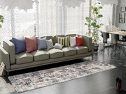 Designer Teppich in einem modernen Wohnzimmer, perspektivisch von oben betrachtet, mit einem Sofa und dekorativen Kissen im Hintergrund.