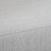 Nahaufnahme eines Loungesessels mit hellgrauem, strukturiertem Stoffbezug.