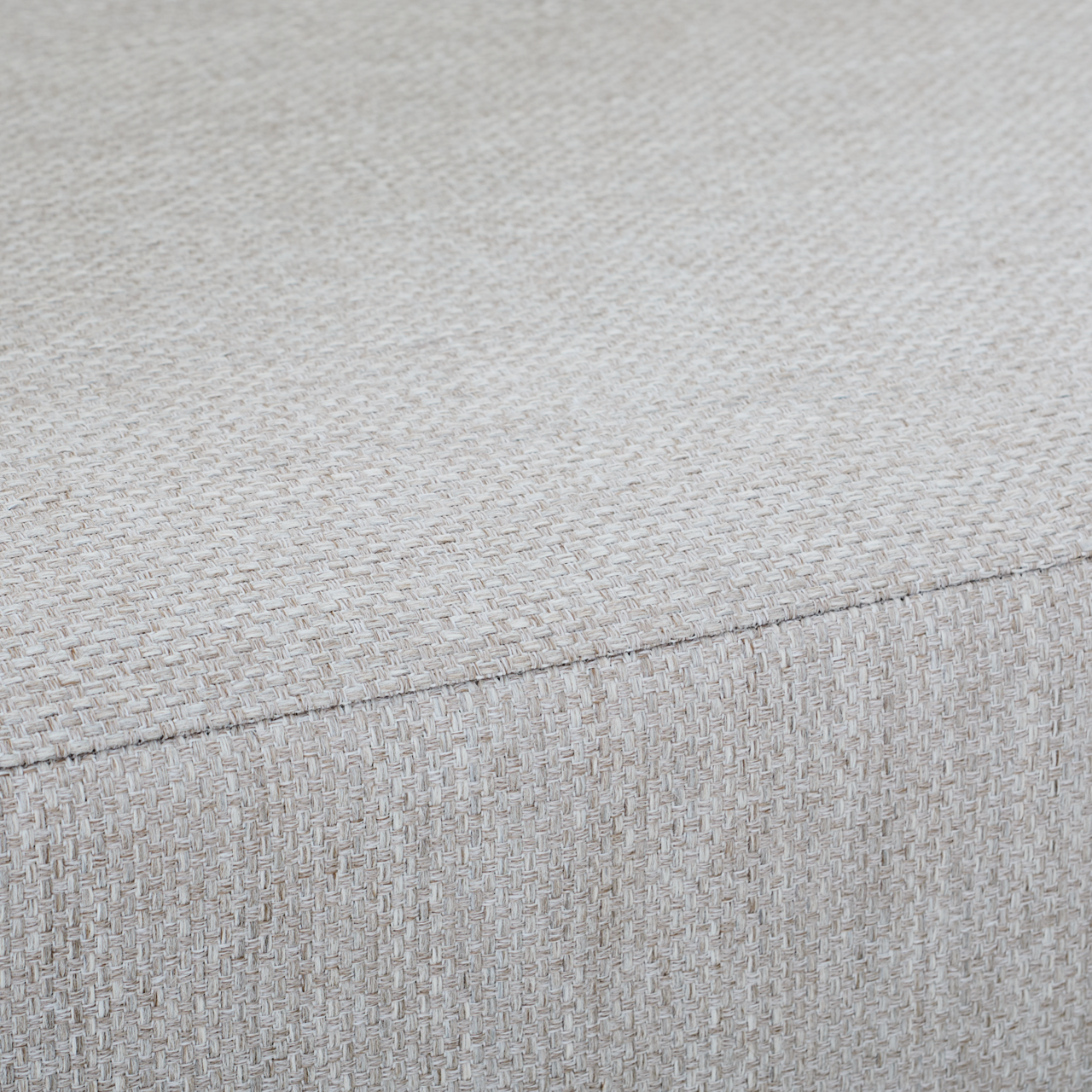 Nahaufnahme eines Loungesessels mit hellgrauem, strukturiertem Stoffbezug.