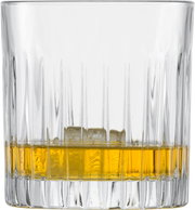 Nahaufnahme eines Whiskyglases mit geriffeltem Design, gefüllt mit goldenem Whisky und Eiswürfeln.