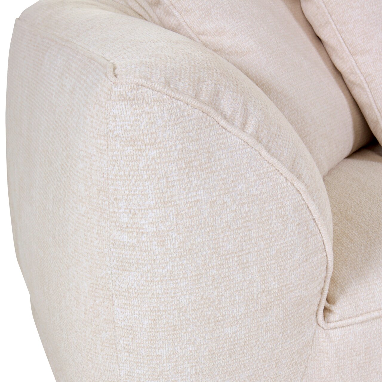 Close-up van een beige grote bank met een zacht, gestructureerd oppervlak en afgeronde armleuningen, gezien vanaf de zijkant.