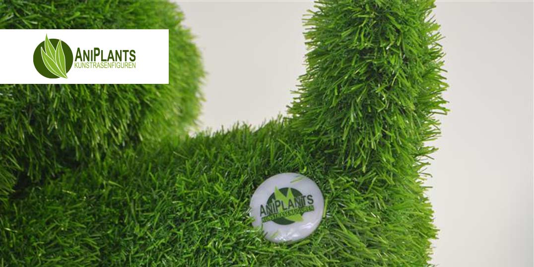 Nahaufnahme einer grünen, grasähnlichen Skulptur mit dem Logo von AniPLANTS.