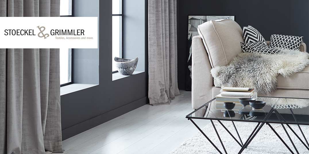  Wohnzimmer mit Sofa, Kissen, und Felldecke der Marke STOECKEL & GRIMMLER