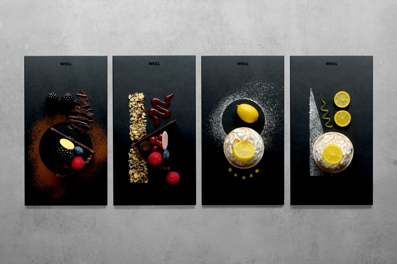 Vier stilvolle Frühstückssets mit verschiedenen Desserts aus der Vogelperspektive: Schokoladenkuchen mit Beeren, Nüssen und Zitronen auf dunklen Platten.