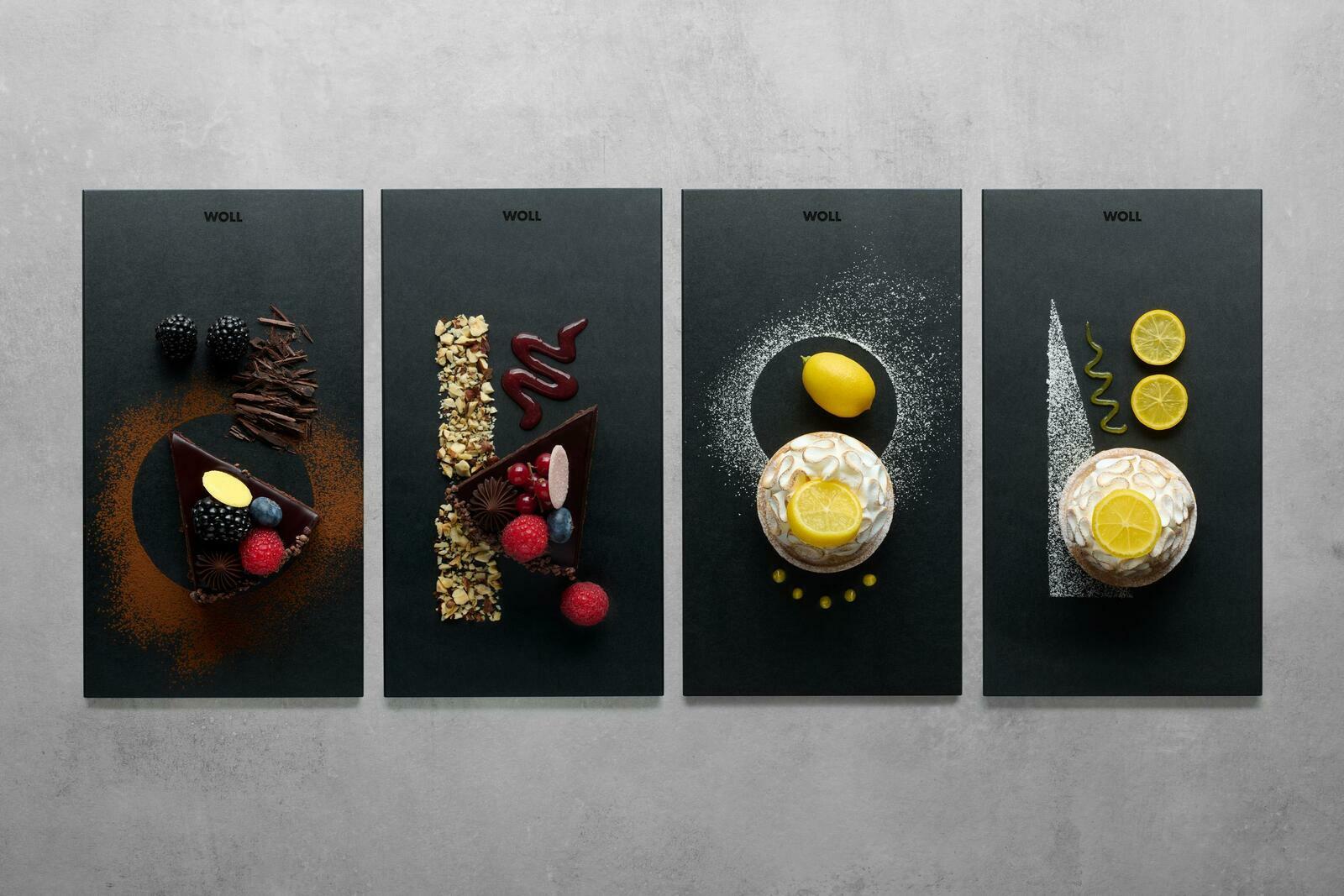 Vier stilvolle Frühstückssets mit verschiedenen Desserts aus der Vogelperspektive: Schokoladenkuchen mit Beeren, Nüssen und Zitronen auf dunklen Platten.