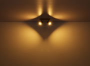 Zwei Strahler aus Metall in Graphit dunkel, an der Decke montiert, werfen warmes Licht und erzeugen ein interessantes Schattenspiel. Perspektive von unten.
