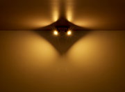 Zwei Strahler aus Metall in Graphit dunkel, an der Decke montiert, werfen warmes Licht und erzeugen ein interessantes Schattenspiel. Perspektive von unten.