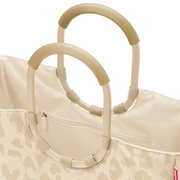 Nahaufnahme einer beigefarbenen Stofftasche mit zwei ovalen, gerippten Tragegriffen und Reißverschlussfach, Ansicht schräg von oben