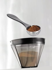 Kaffeemaß Misurino von oben, gefüllt mit gemahlenem Kaffee, neben einem Kaffeefilter.