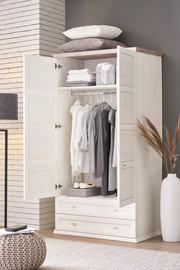 Offener XL-Garderobenschrank in heller Holzoptik, gefüllt mit Kleidung auf Kleiderbügeln und Accessoires, aus der Frontalperspektive fotografiert.
