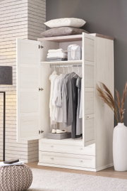 Open XL-garderobekast in lichte houtlook, gevuld met kleding aan kleerhangers en accessoires, gefotografeerd vanuit een vooraanzicht.