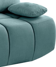 Nahaufnahme eines türkisfarbenen Schlafsofas mit geripptem Stoffbezug und einem Kissen, seitliche Perspektive.