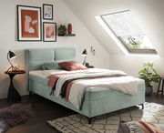 Modernes Boxbett in einem stilvoll eingerichteten Schlafzimmer mit Dachfenster, aus der Seitenperspektive fotografiert.