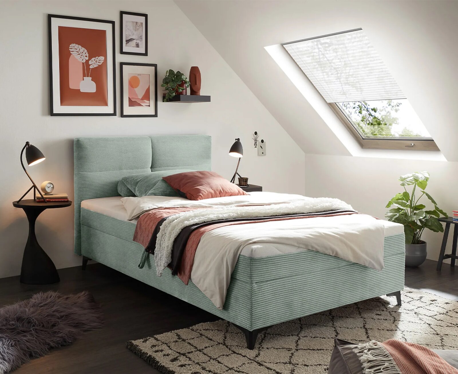 Modern boxbed in een stijlvol ingerichte slaapkamer met dakraam, gefotografeerd vanuit een zijaanzicht.