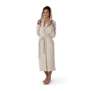 Frau in einem cremefarbenen Kapuzenbademantel, stehend in Frontalansicht, mit Kapuze auf dem Kopf und Gürtel um die Taille.