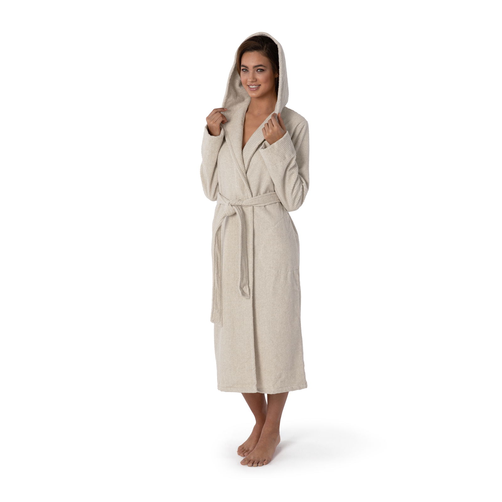 Frau in einem cremefarbenen Kapuzenbademantel, stehend in Frontalansicht, mit Kapuze auf dem Kopf und Gürtel um die Taille.