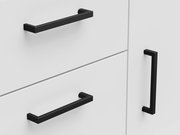 Nahaufnahme einer weißen Kommode mit schwarzen Griffen, seitliche Perspektive