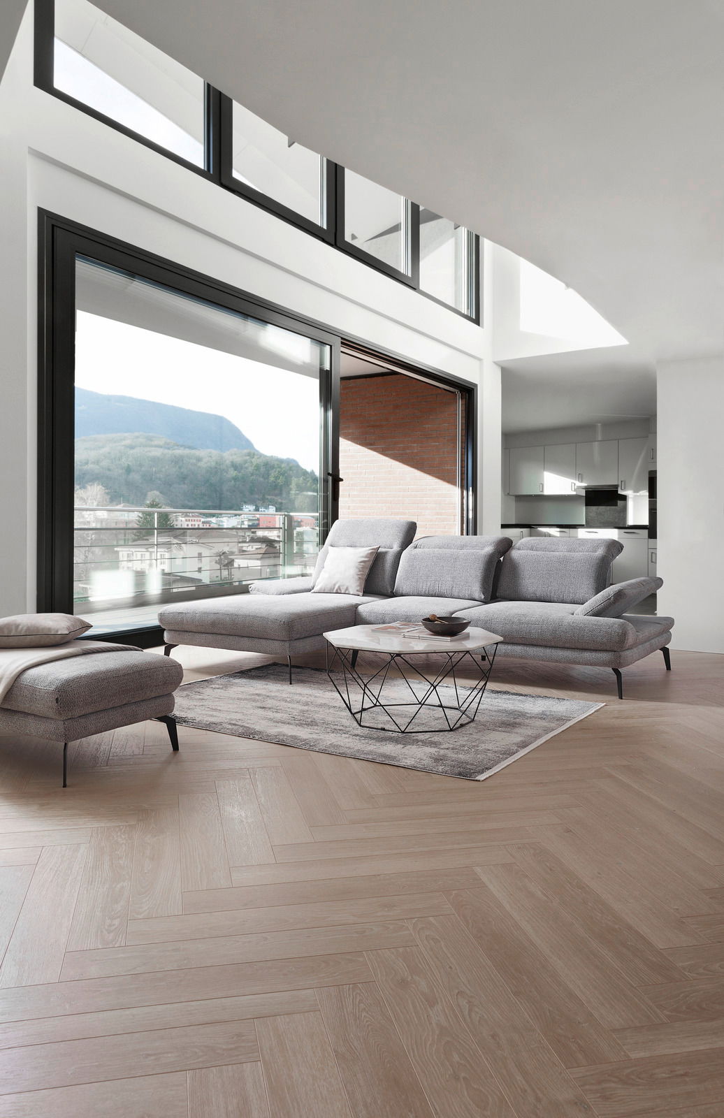 Moderne Longchairkombination in einem hellen Wohnzimmer mit Blick auf die Terrasse. Perspektive von vorne links.