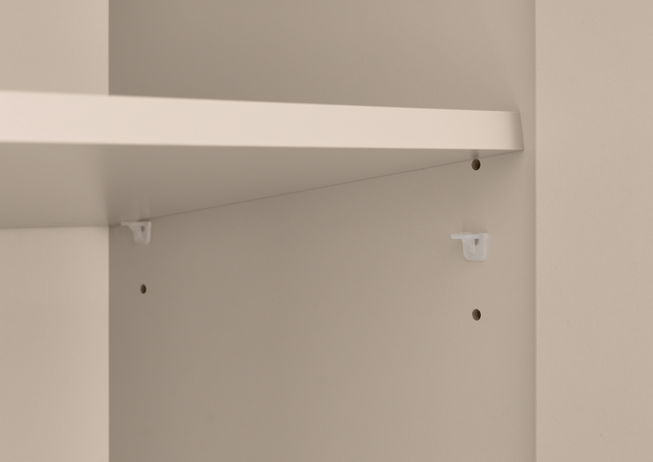 Detailansicht eines weißen Möbelkorpus mit eingelegtem Regalboden und Halteclips, fotografiert aus leicht schräger Seitenperspektive von innen.