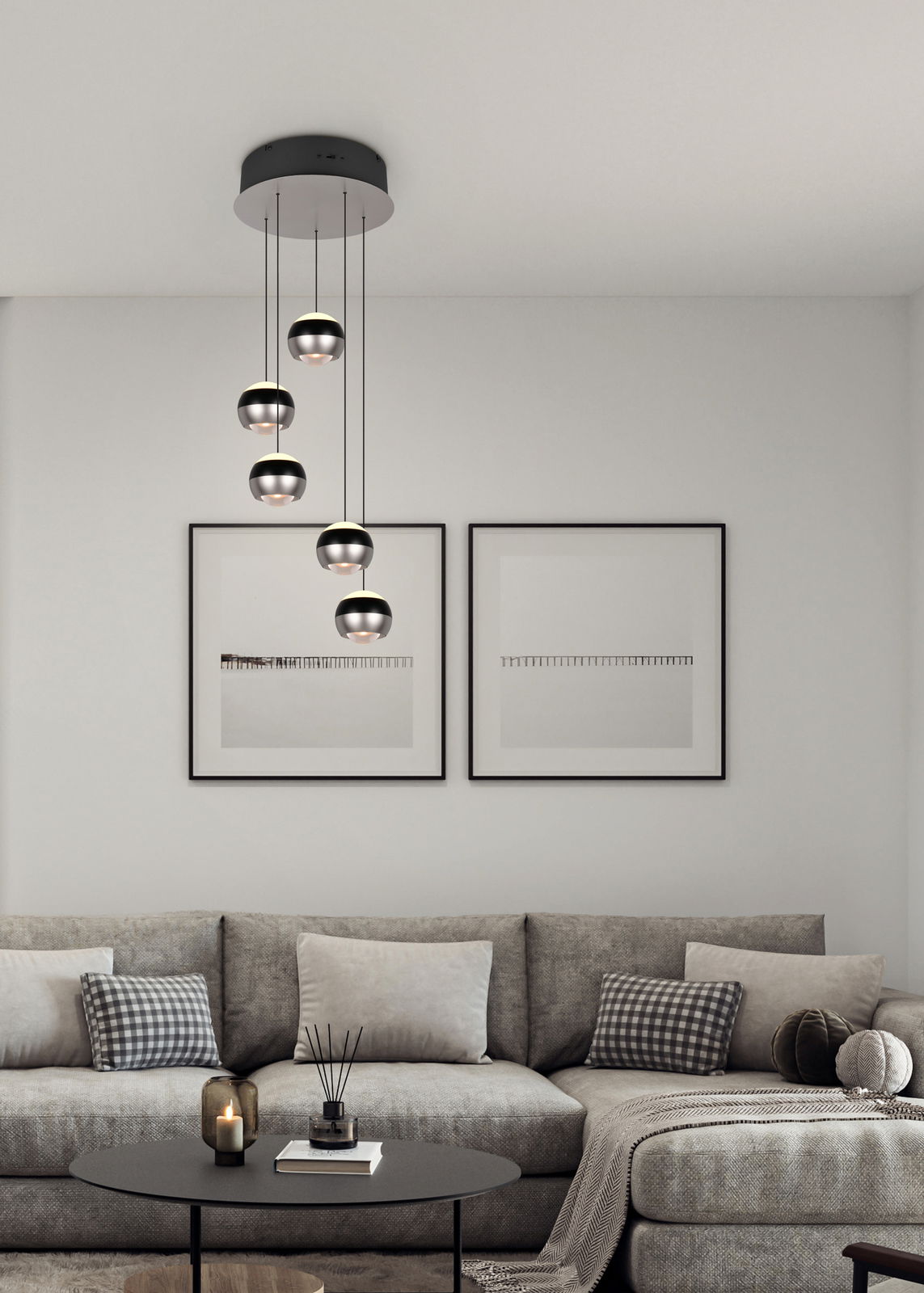 Trio Leuchten Pendelleuchte Orbit Moderne Pendelleuchte Orbit mit fünf kugelförmigen Lampen, hängend von einer schwarzen Deckenhalterung, in einem stilvollen Wohnzimmer mit grauem Sofa und minimalistischer Dekoration. Perspektive von vorne.