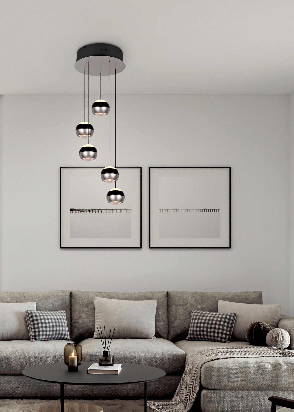 Trio Leuchten Pendelleuchte Orbit Moderne Pendelleuchte Orbit mit fünf kugelförmigen Lampen, hängend von einer schwarzen Deckenhalterung, in einem stilvollen Wohnzimmer mit grauem Sofa und minimalistischer Dekoration. Perspektive von vorne.