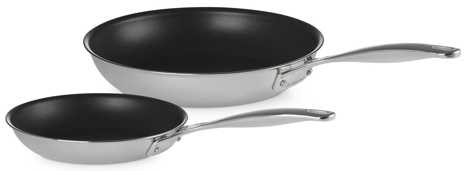 LE CREUSET Pfannenset 2-tlg. 3-PLY Zwei silberne 3-PLY PLUS Pfannen in den Größen 20cm und 26cm, aus der Vogelperspektive fotografiert.