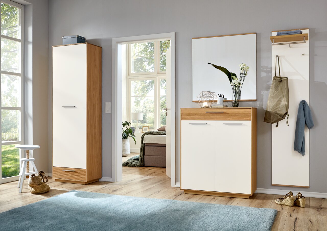 Moderne halmeubelset in lichte hal met hoge kast en schoenenkast met spiegel, wit front en eikenlook, gefotografeerd in frontaal perspectief op ooghoogte.