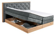 Boxspringbett mit grauem Stoffbezug und Stauraum, seitliche Perspektive
