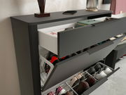 Schuhschrank in moderner Perspektive mit geöffneten Schubladen, die Schuhe und Accessoires zeigen.