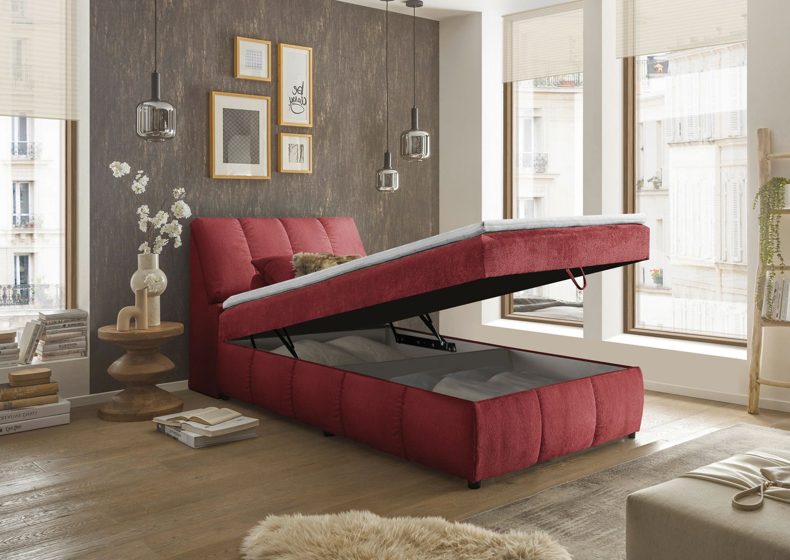 Rotes Boxspringbett mit Stauraum, seitliche Perspektive, in modernem Schlafzimmer mit großen Fenstern und stilvoller Dekoration.