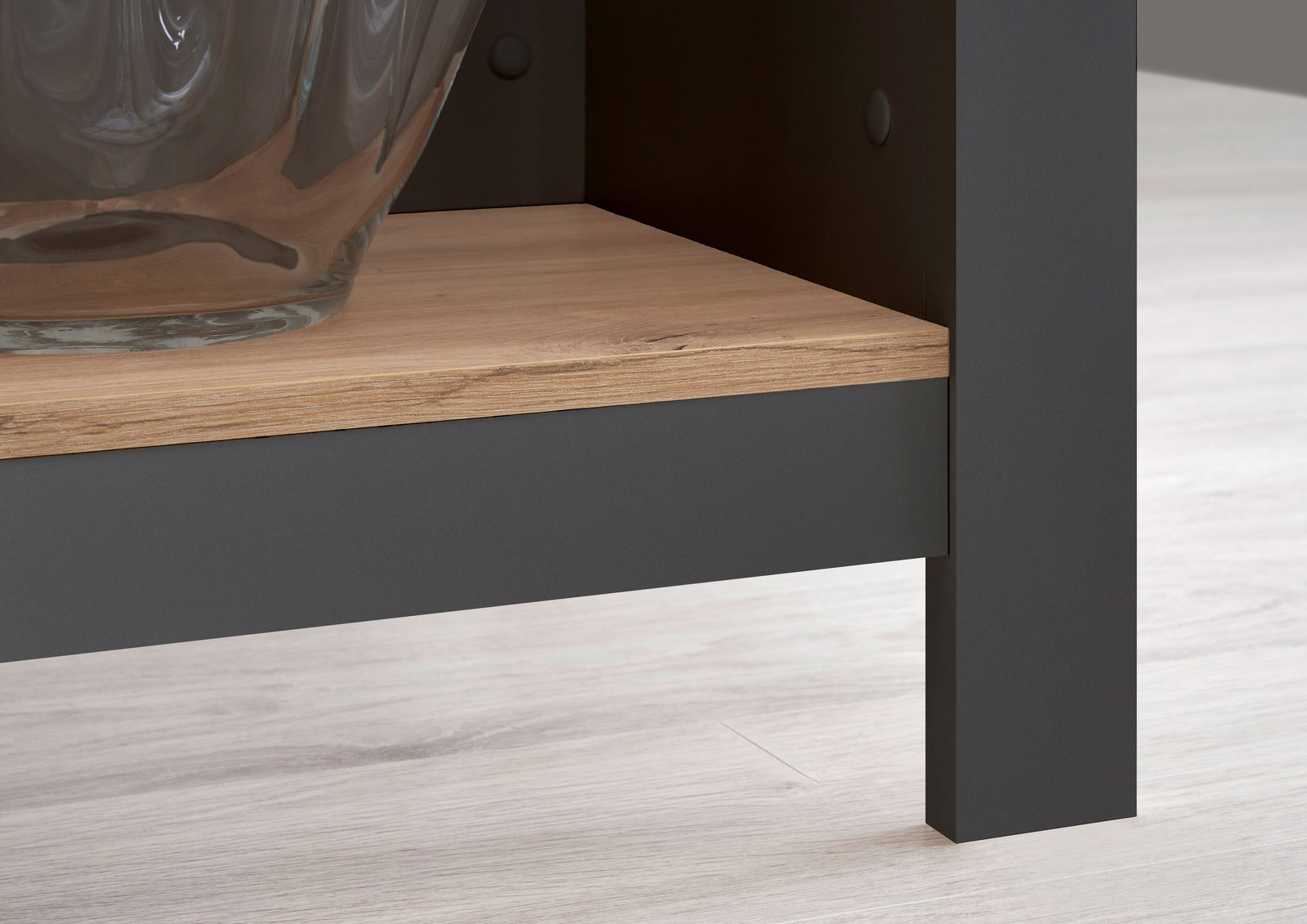 Nahaufnahme einer Kücheninsel mit einer Holzablage und einem Glasgefäß, seitliche Perspektive.