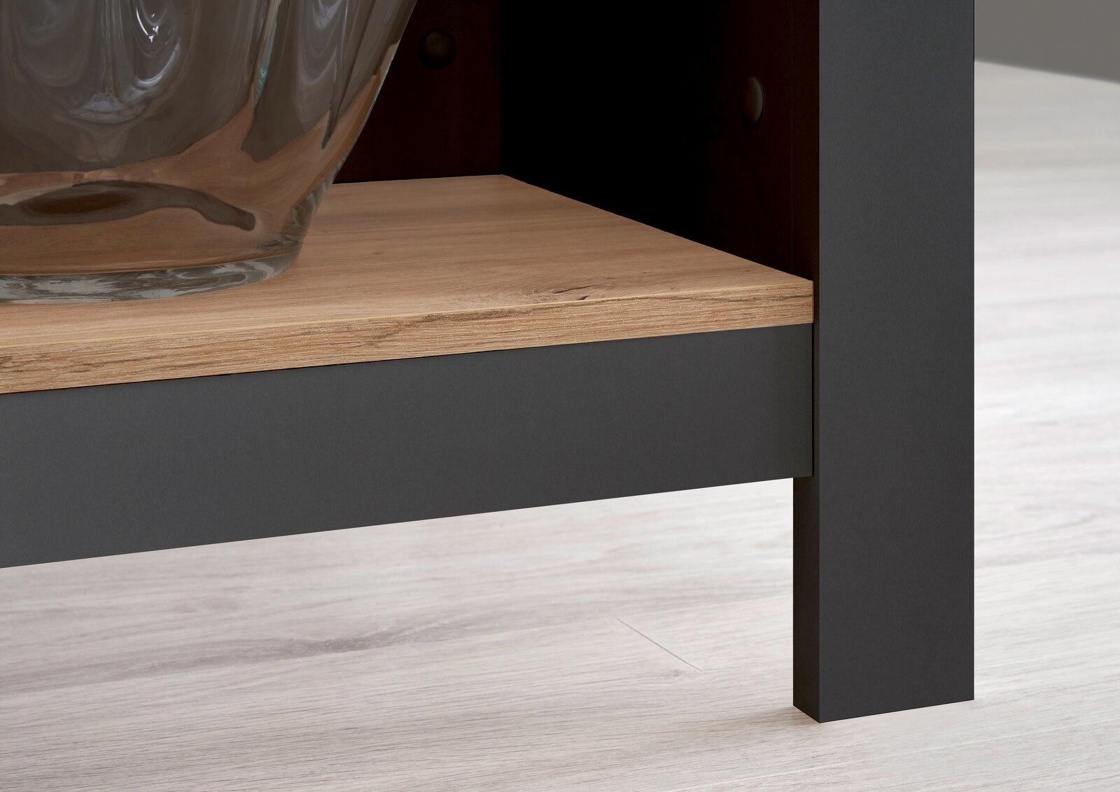 Nahaufnahme einer Kücheninsel mit einer Holzablage und einem Glasgefäß, seitliche Perspektive.