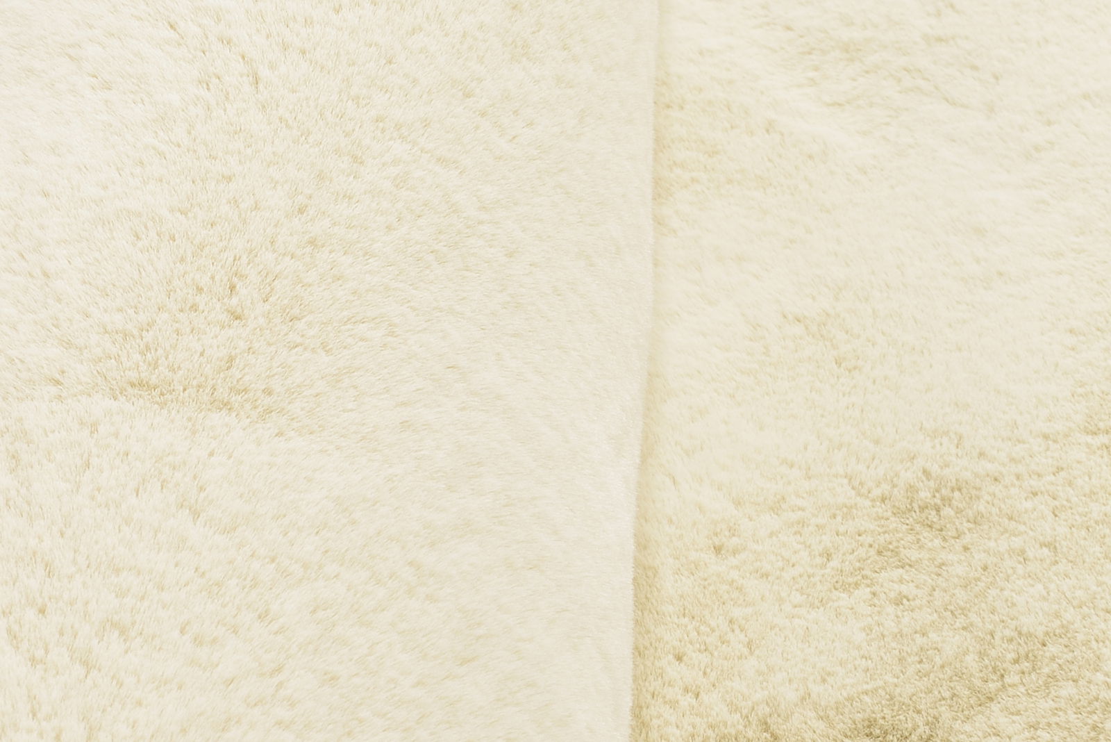 Nahaufnahme eines cremefarbenen Fellteppichs mit weicher Textur