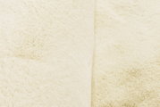 Nahaufnahme eines cremefarbenen Fellteppichs mit weicher Textur