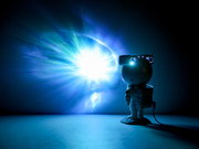 LED-Dekoleuchte in Form eines Astronauten, der eine leuchtende Projektion an die Wand wirft, seitliche Perspektive.