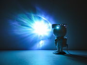 LED-Dekoleuchte in Form eines Astronauten, der eine leuchtende Projektion an die Wand wirft, seitliche Perspektive.