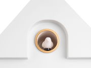 Nahaufnahme einer weißen Wanduhr mit einem kleinen Vogel in einem goldenen Ring.