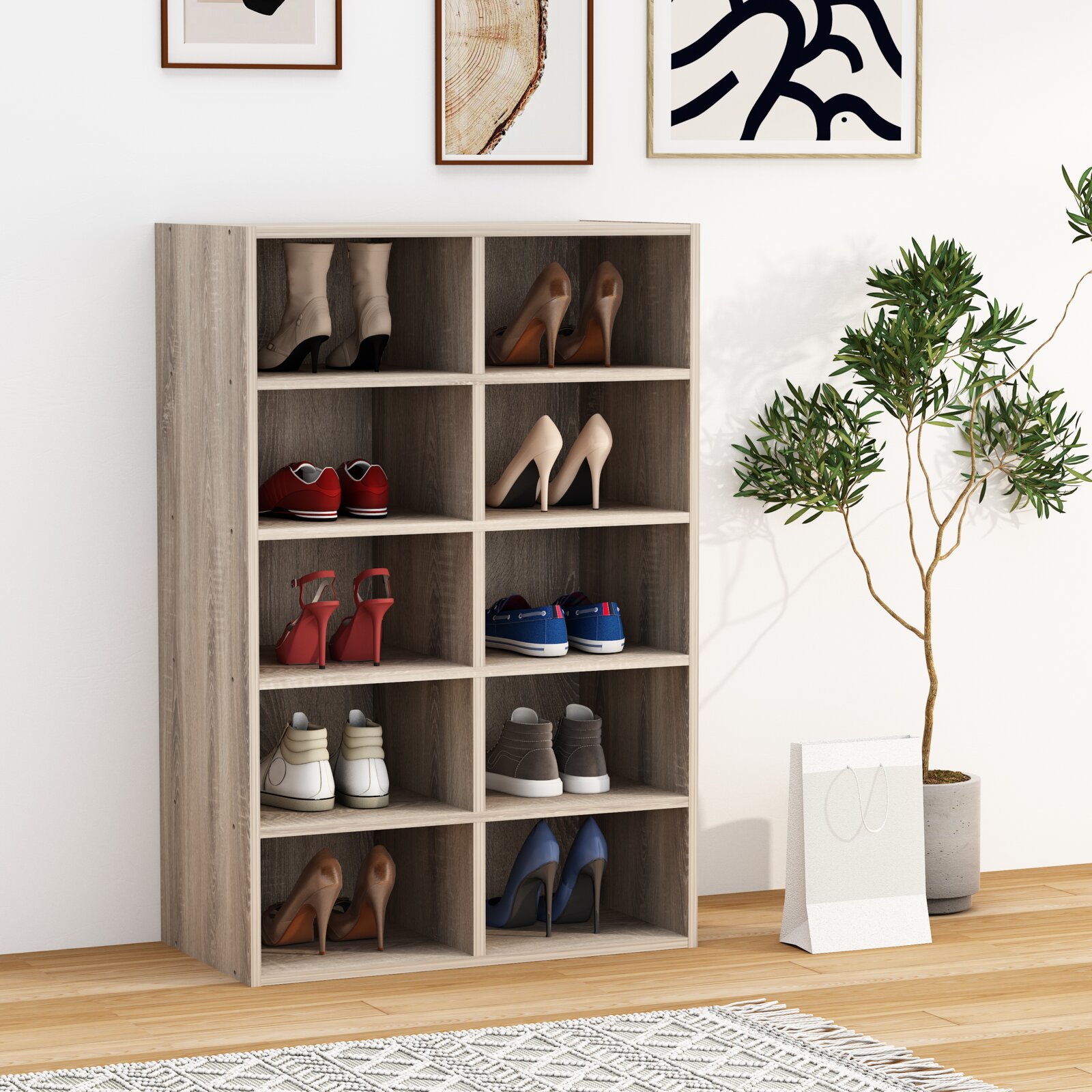 Schuhregal in heller Holzoptik mit 10 offenen Fächern, befüllt mit verschiedenen Schuhen, freistehend im Wohnraum; Perspektive: frontale leicht schräge Ansicht von vorn links.