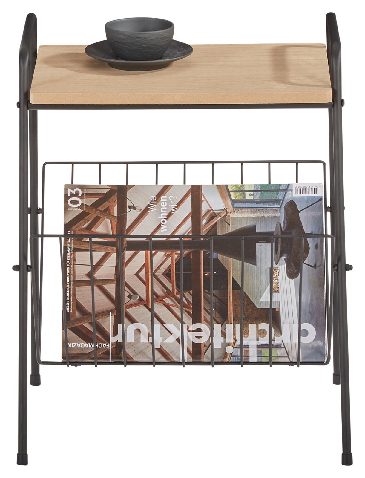Beistelltisch mit Holzplatte und schwarzem Metallgestell, darauf eine schwarze Tasse mit Untertasse, darunter ein Magazinhalter mit Zeitschrift, Ansicht von vorne.
