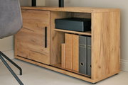 Nahaufnahme eines Eck-Schreibtisch-Kombinationselements aus Holz mit einem Schrank und Regalfächern, gefüllt mit Ordnern und einer Box, von der Seite betrachtet.