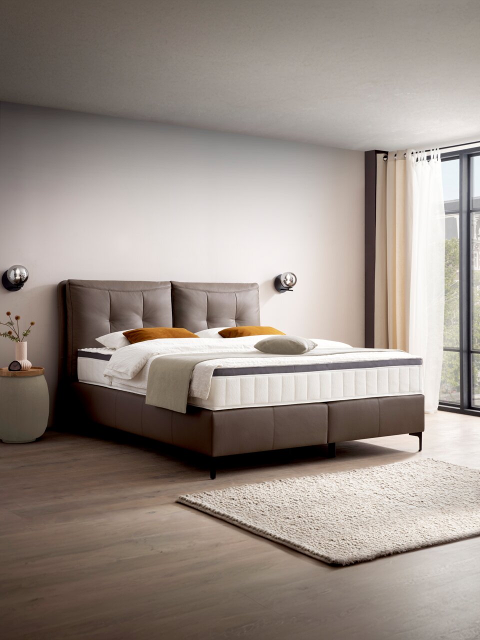 Modernes Boxspringbett in einem stilvollen Schlafzimmer, seitliche Perspektive