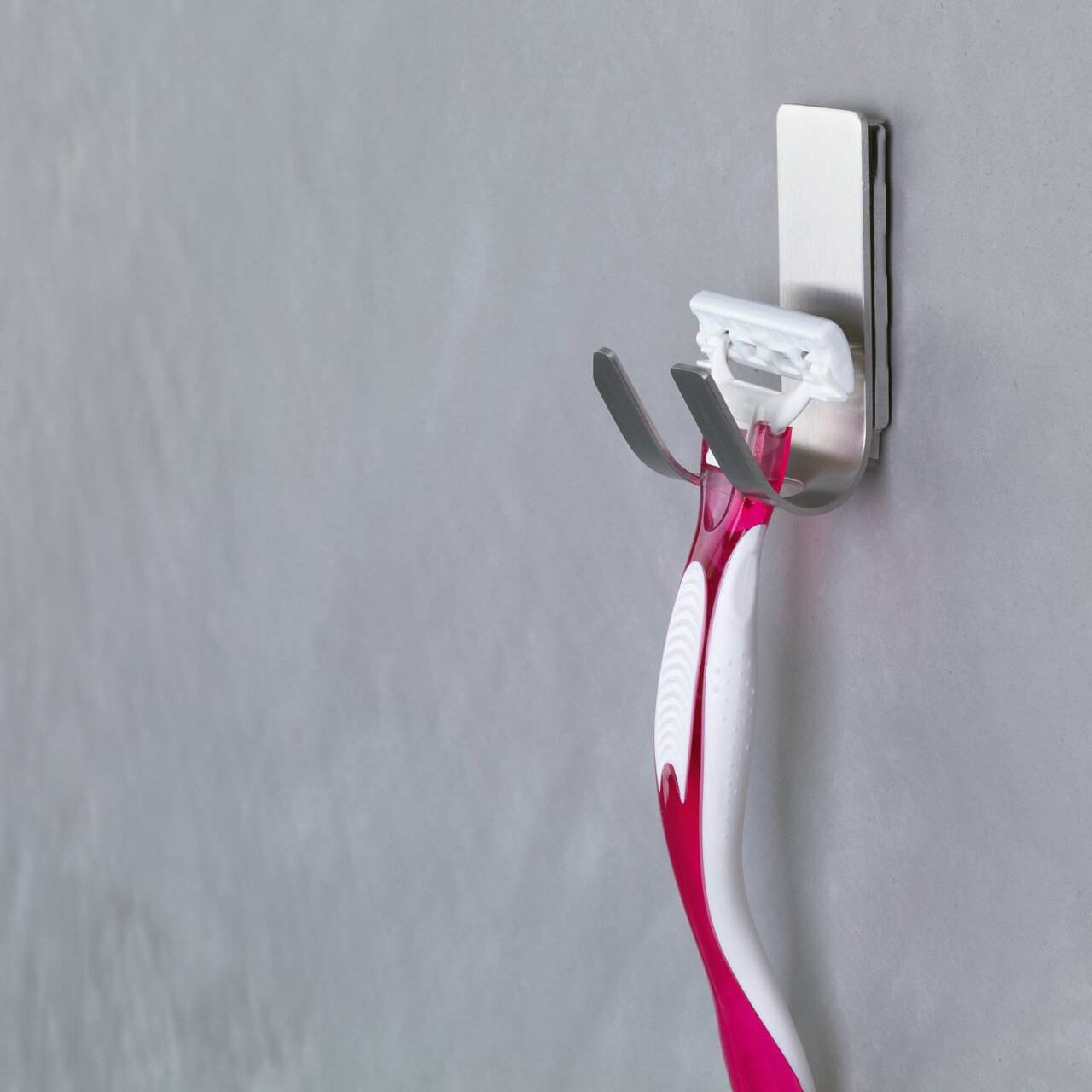 Scheerhouder bevestigd aan een muur met tesa Powerstrips Waterproof, zijaanzicht