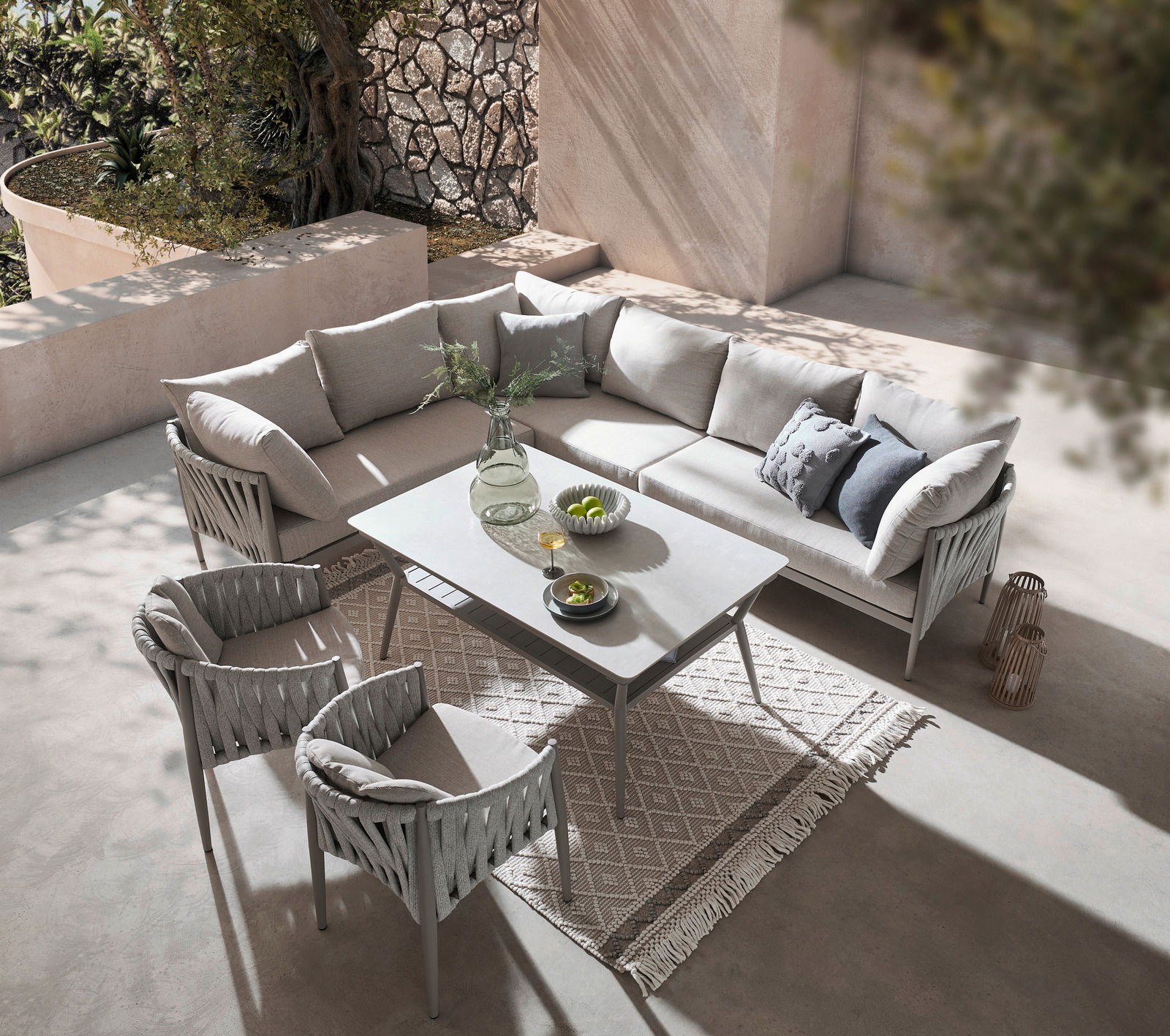 Moderne Gartensitzgruppe mit Ecksofa und zwei Sesseln, von oben fotografiert, auf einer Terrasse mit stilvoller Dekoration.