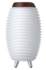 Weiße, geriffelte Akku-Leuchte mit Lautsprecher, seitliche Perspektive, auf drei Metallfüßen stehend, mit braunem Ledergriff oben.