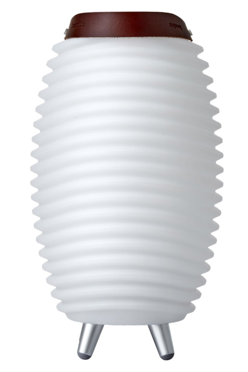 Weiße, geriffelte Akku-Leuchte mit Lautsprecher, seitliche Perspektive, auf drei Metallfüßen stehend, mit braunem Ledergriff oben.